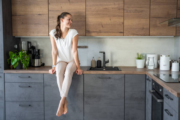istock Woman sitting on her kitchen counter at home 2149540647
