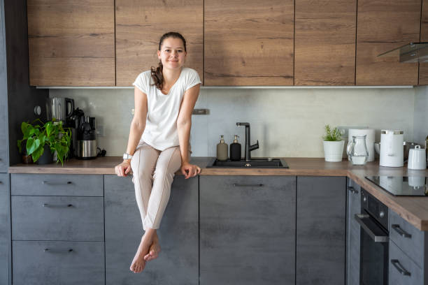 istock Young woman sitting on her kitchen counter at home 2149540653