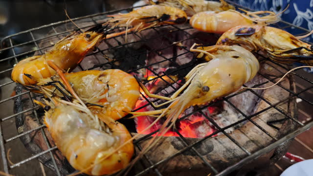 Shrimps on the grill in an open fire ready to eat at street food Thailand