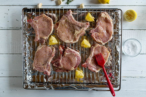 Raw and fresh marinated pork chops on a oven rack