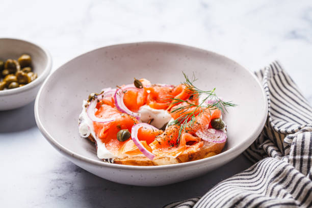 istock Breakfast bagel with salmon, cream cheese, capers and onions, white background. 2149547972
