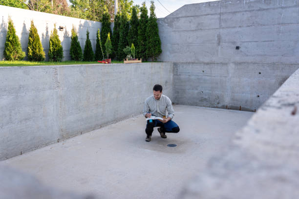 istock Civil engineer on a construction site holding blueprints and project plans while carefully observing the progress of the work 2149549096