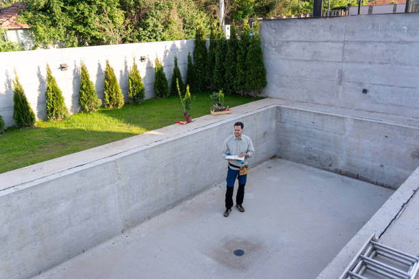 Master engineer inspecting the construction of a luxurious yard and swimming pool stock photo
