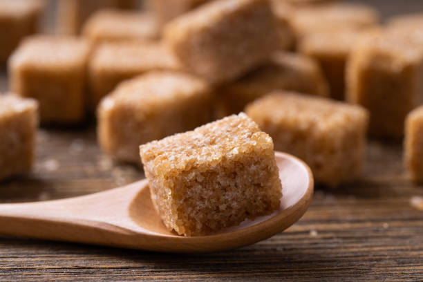 istock Natural brown sugar cubes on wood background. 2149550254