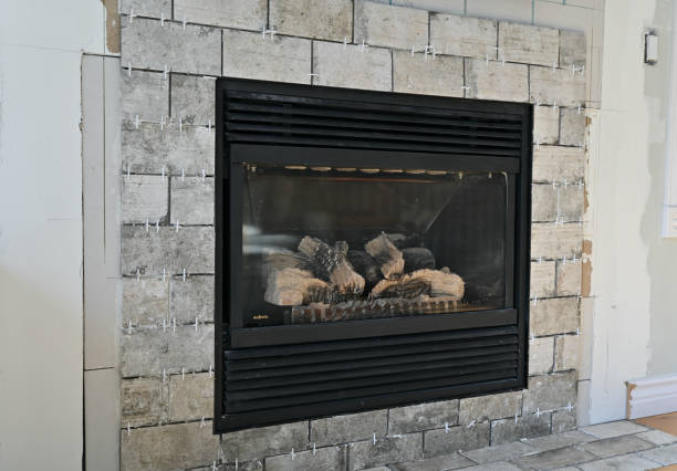 Home renovation projects, simple weekend construction to update and modernize the living room Home renovation projects replacing tile surround on gas fireplace in family room to revitalize the room drywall fireplace stock pictures, royalty-free photos & images