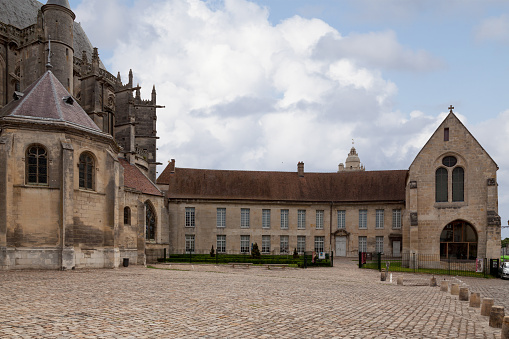 Senlis, France - July 19 2017: Parvise of the cathedral Notre-Dame de Senlis with the old episcopal palace. An Episcopal Palace (also known as a Bishop's Palace) is, or has been in the past, the official residence of a bishop.