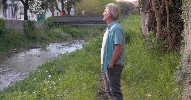 istock Mature man pauses on riverbank 2149555362