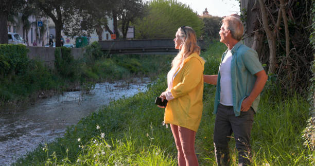 istock Mature couple walk along riverbank 2149555387