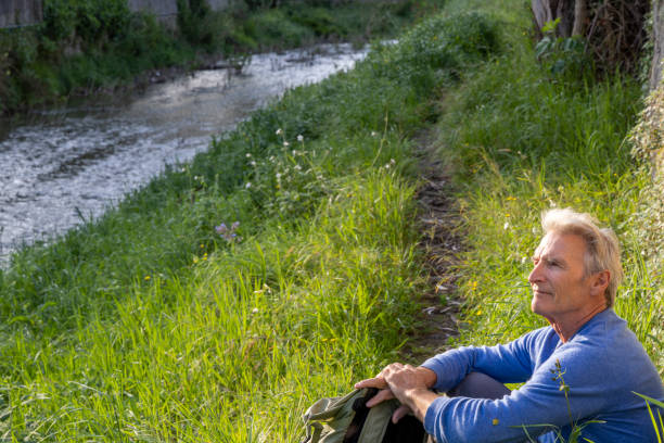 istock Mature man pauses on riverbank 2149555560