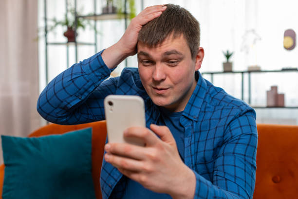 istock Sad displeased man using smartphone browsing loses surprised game results bad news fail app virus 2149555615