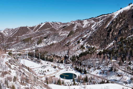 Almaty, Kazakhstan - March 18, 2024: Medeu high-mountain sports complex for winter sports, skating rink. Water pool for technical block. Located on northern slope of Trans-Ili Alatau ridge. Top view.