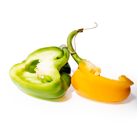 Green and yellow pepper on the white background with
pepper seed nest.