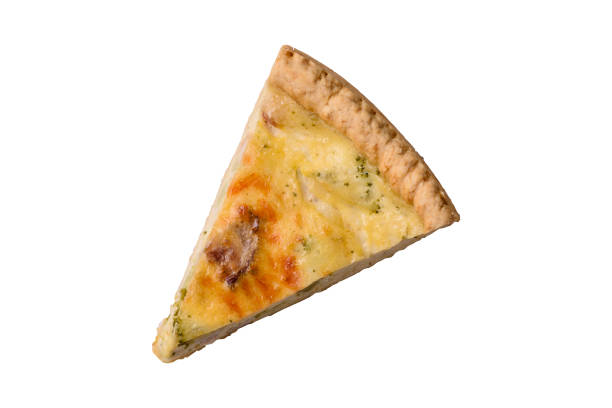 A wooden platter displays colorful quiche slices filled with spinach and tomatoes, accompanied by grapes, offering a savory, gourmet meal option.