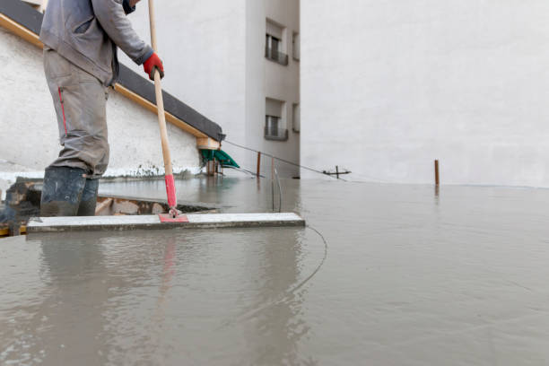 istock Process leveling floor after pouring concrete. Laborer leveling  concrete plate with square trowel on a construction site. 2149563588