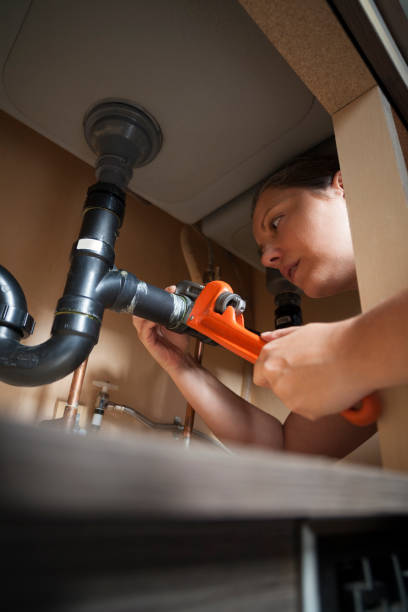 istock Woman Plumber Fixing a Kitchen Sink 2149566396