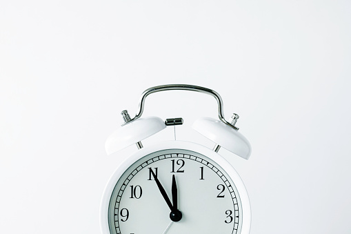 Retro style alarm clock on white background.
