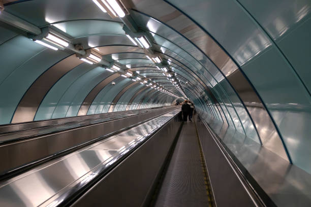Escalator and moving walkway in a metro tunnel.