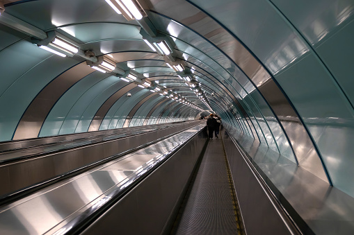 Escalator and moving walkway in a metro tunnel.