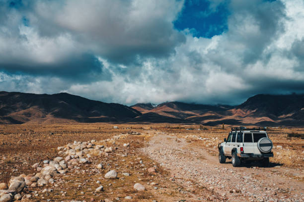 SUV driving up dirt road in the mountains