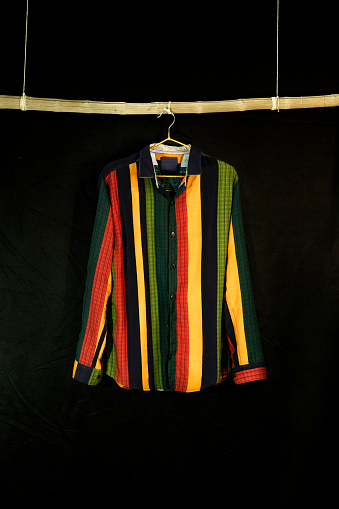 Stylish Colorful casual shirt hanging on the wooden stick for display