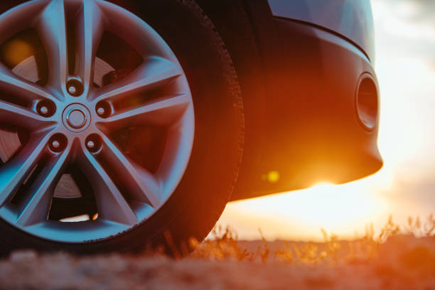 Car wheel close-up view in desert area at sunset
