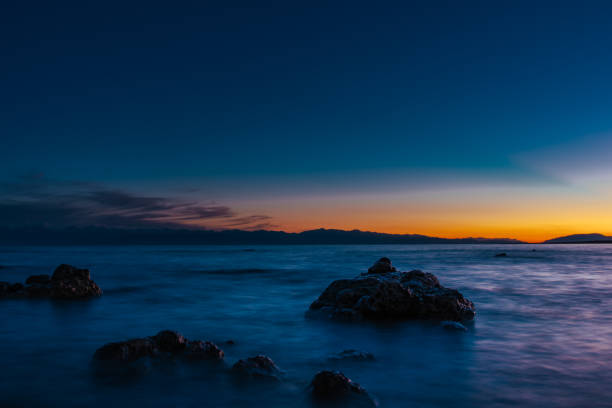 Lake landscape with big stones at dark sunset, long exposure blurred motion
