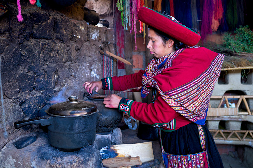 Indigenous woman from the Chinchero town of Peru preparing natural materials to dye the threads that will create the fabrics