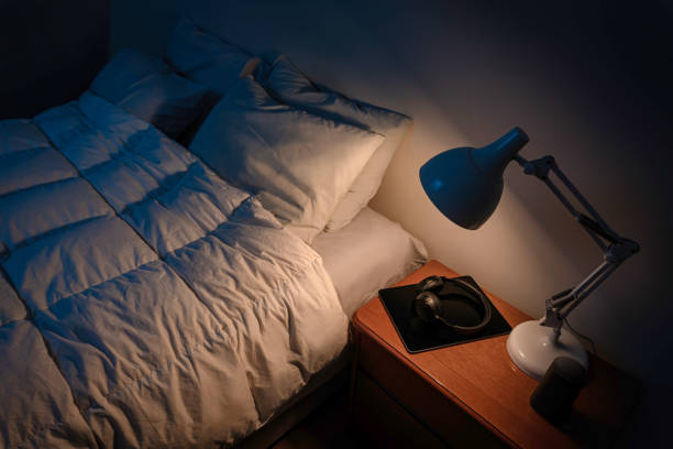 istock A bedroom illuminated by a night lamp and an empty bed. 2149578293