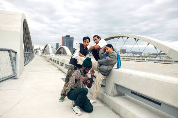 Low angle shot of biracial bad boy band dressed in street style clothes looking at camera