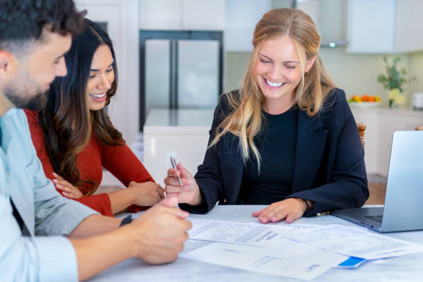 istock Real Estate or Insurance agent with couple looking through documents. 2149582015