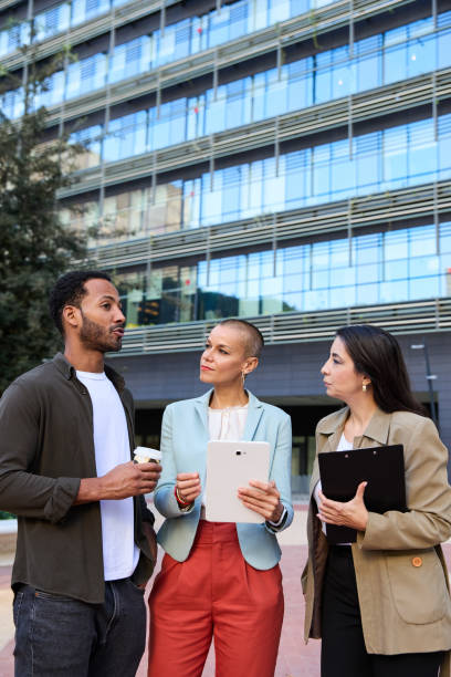 istock Cheerful coworkers using tablet to discuss business on street 2149583814