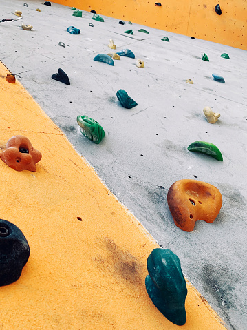 Bouldering colorful professional climbing wall with stones close up, sport background