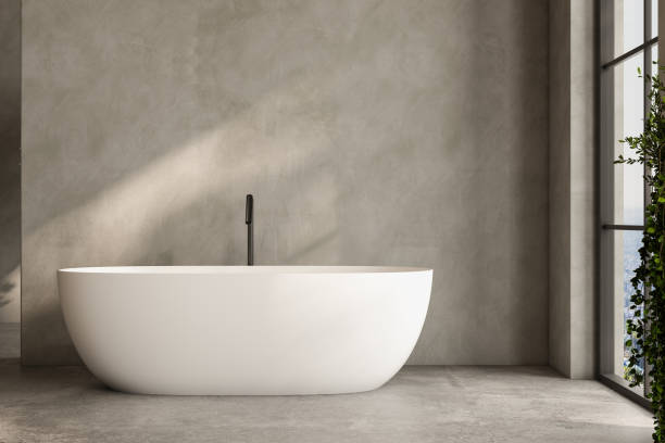 istock A white bathtub sits in a room with a window and a plant 2149584922