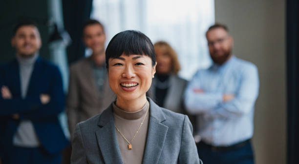 istock A Happy Beautiful Businesswoman Looking At Camera While Being At Work With Her Colleagues 2149585744