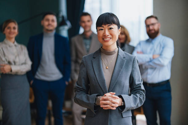 istock A Happy Beautiful Businesswoman Looking At Camera While Being At Work With Her Colleagues 2149585748
