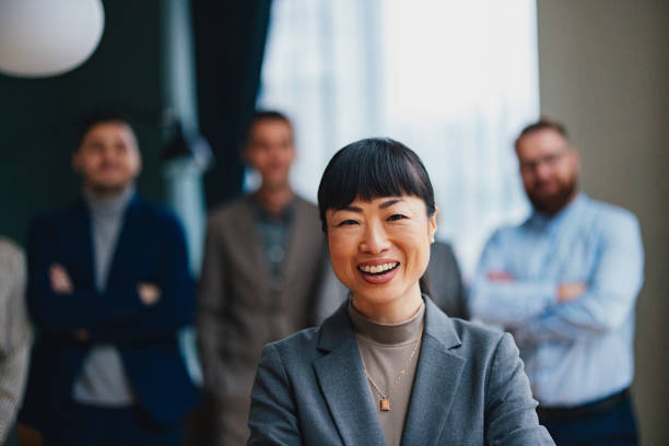 istock A Happy Beautiful Businesswoman Looking At Camera While Being At Work With Her Colleagues 2149585753