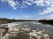 flood on the river in spring. ice floes float on the river against the background of a blue sky with clouds