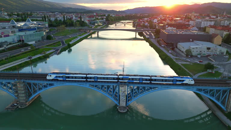 AERIAL Drone Shot of Train on Railway Bridge Over Drava River in Maribor City