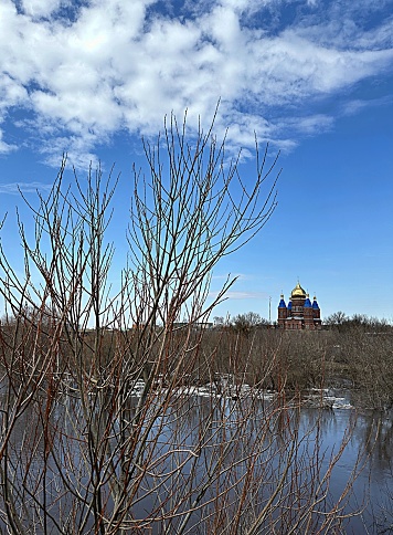 flood on the river in spring. ice floes float on the river against the background of a blue sky with clouds.