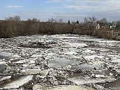 flood on the river in spring. ice floes float on the river against the background of a blue sky with clouds