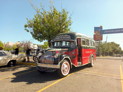 Buenos Aires, Argentina - Dec 10, 2023: old red 1946 Chevrolet AK series bus for public passenger transport in Buenos Aires at a classic car show in a parking lot. Traditional fileteado ornaments. Copy space