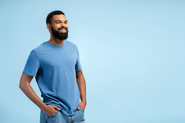 istock Smiling African American man looking away in studio over blue background with copy space 2149592421