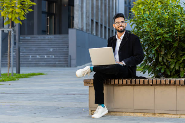 istock Happy Indian businessman typing working remote on wireless laptop computer browsing online outdoors 2149593210