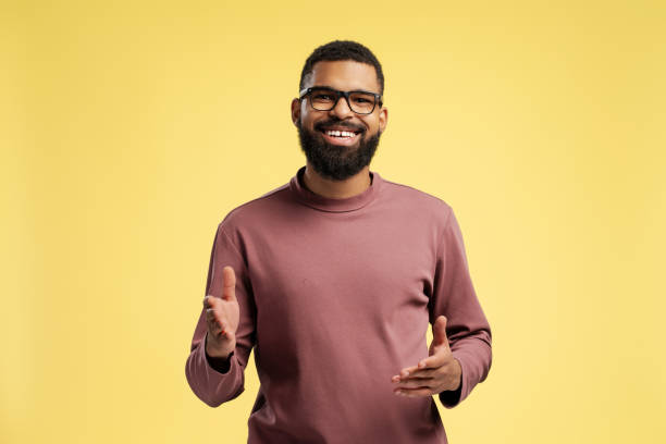 istock Happy young African American man wearing eyeglasses while posing in studio, over yellow background 2149593423