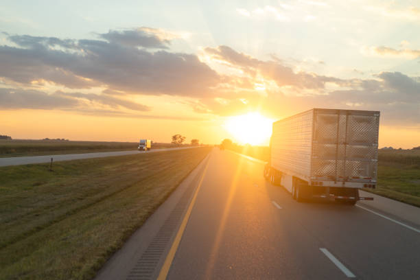 istock Sunset Hues Casting Golden Light on a Freeway with Moving Truck 2149593883