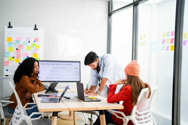 istock Creative team collaborates on a project with a laptop and digital screen in a modern office, recorded by a camera. Young business analyst evaluates environmental performance on screen in eco-strategy. 2149597774
