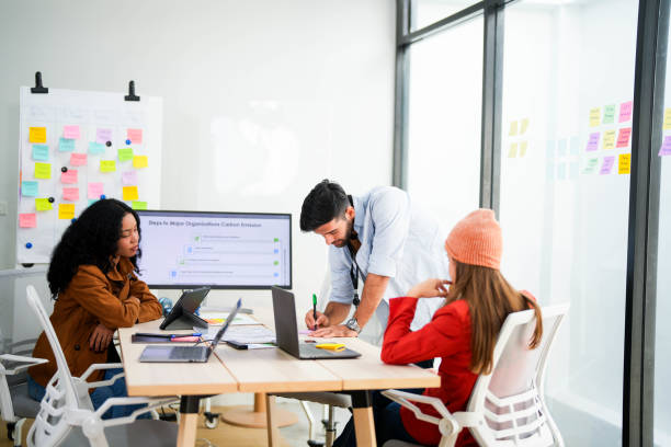 istock Creative team collaborates on a project with a laptop and digital screen in a modern office, recorded by a camera. Young business analyst evaluates environmental performance on screen in eco-strategy. 2149598192
