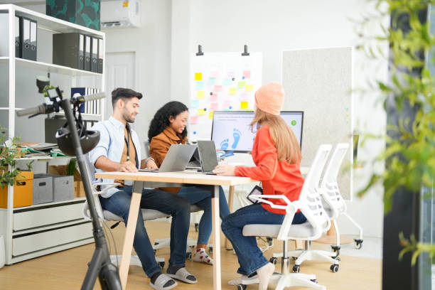istock Creative team collaborates on a project with a laptop and digital screen in a modern office, recorded by a camera. Young business analyst evaluates environmental performance on screen in eco-strategy. 2149598399