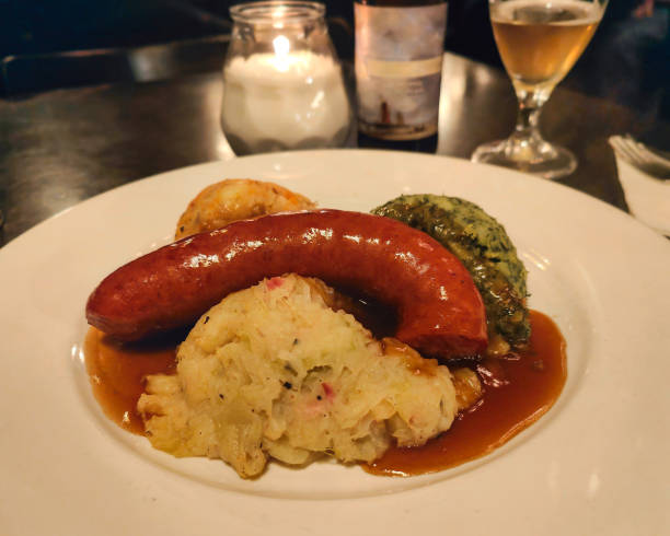 Close-up shot of traditional Dutch main course meal. a smoked sausage with a combination of hutspot (boiled & mashed potatoes with onion,carrot), boerenkoolstamppot ( mashed potatoes and kale )  and zuurkoolstamppot ( Dutch sauerkraut and potato dish)