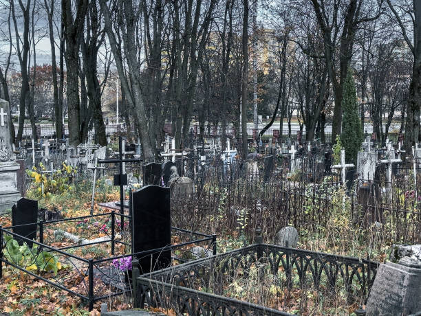 Gloomy cemetery, graveyard with tombstones, crosses and trees